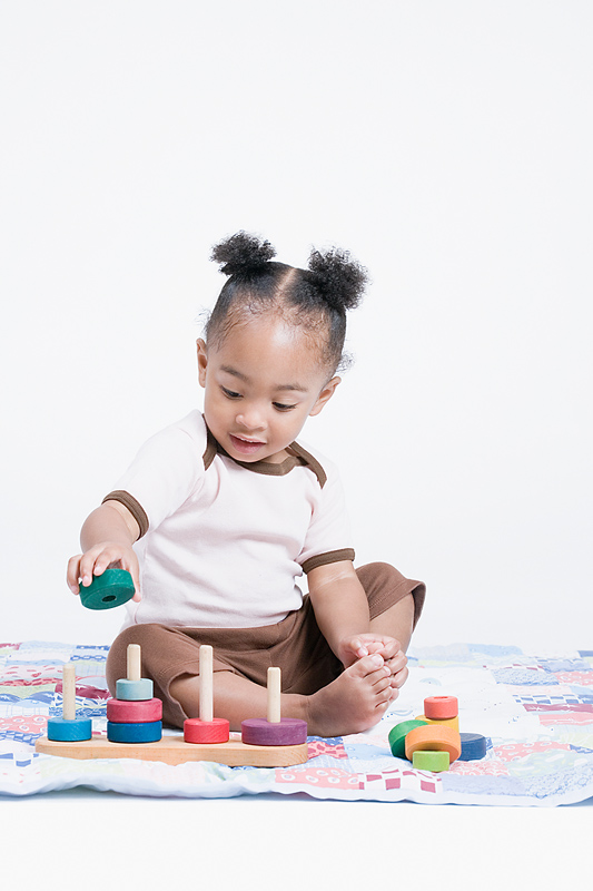 baby playing with wooden toy on the floor