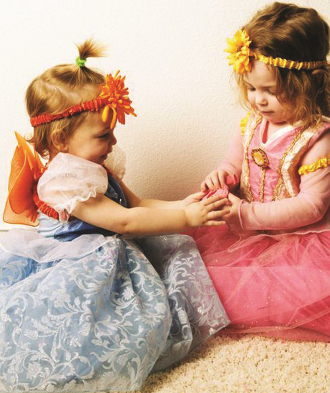 two young girls in dress up holding hands