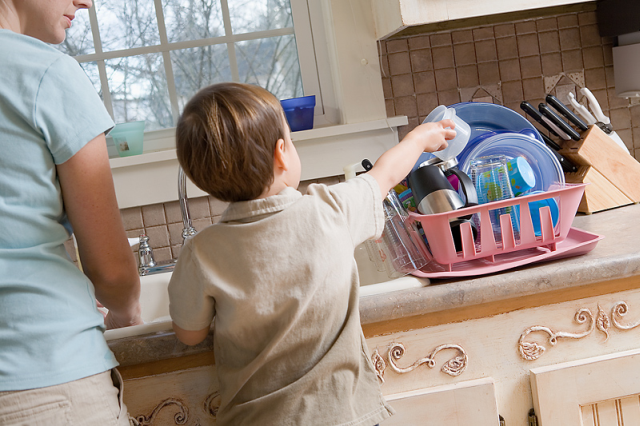 young boy helping load dishwasher