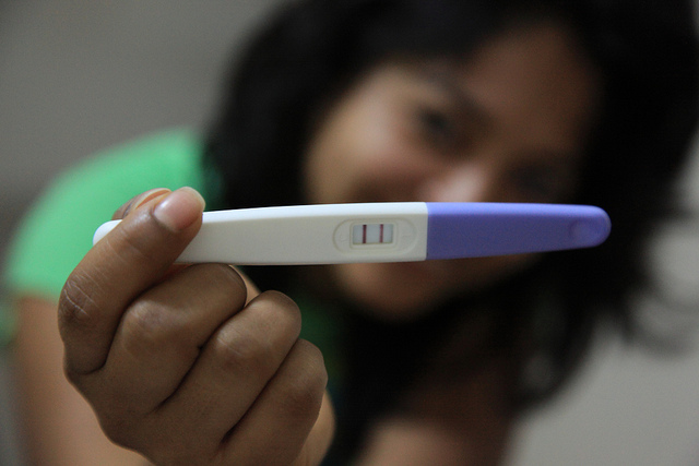 Mujer con resultados positivos de la prueba de embarazo