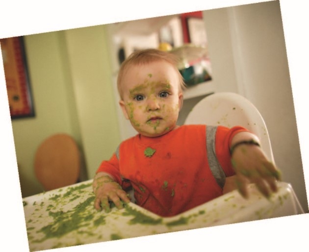 Baby covered in their food in the high chair