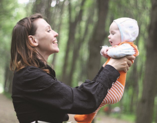 Mom holding her baby and smiling at them