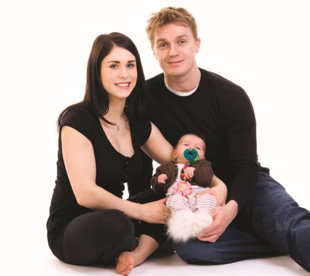 Couple sitting and holding their baby