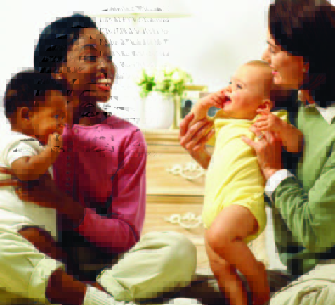 Two moms sitting and playing with their babies