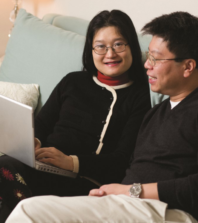 Couple talking and using a laptop