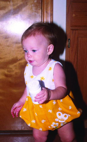 Baby holding a pill bottle