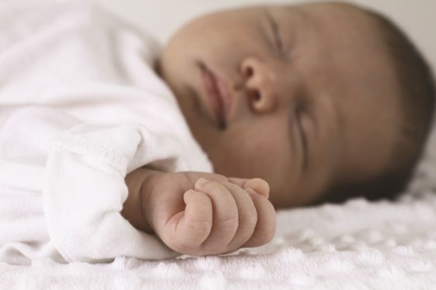 Newborn baby laying on bed