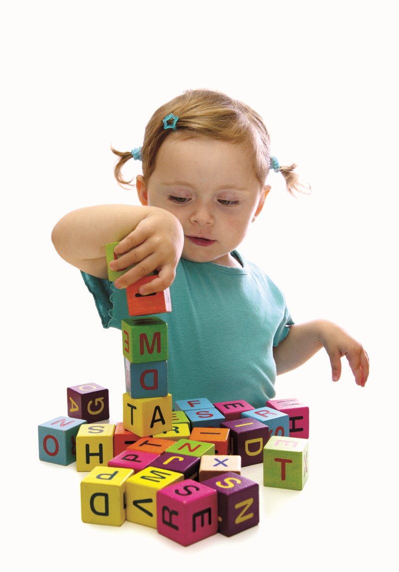 Young girl playing with letter blocks