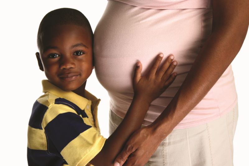 Niño abrazando a la barriga de su mamá embarazada