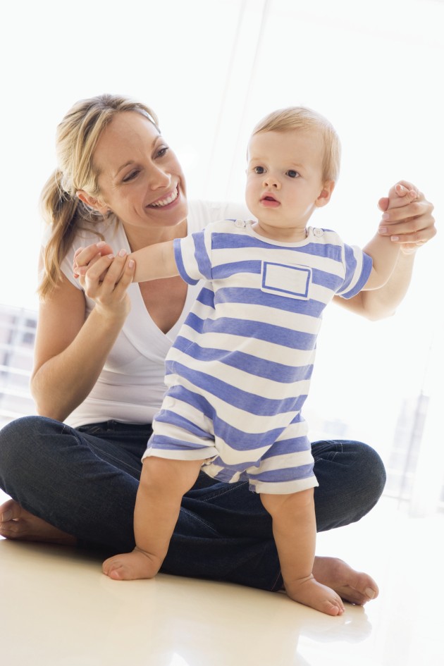 Mom helping her baby stand