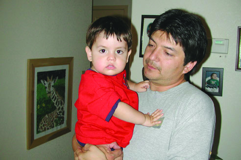 Papá y bebé sonrientes  mientras carga a su hijo