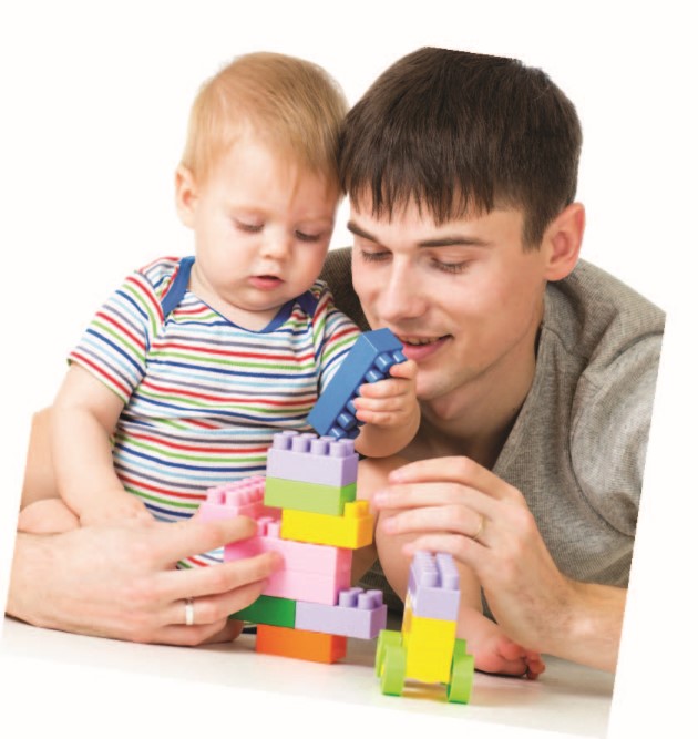 Bebé sostenido por joven adulto colocando juntos piezas de lego o duplo en una estructura de colores pastel