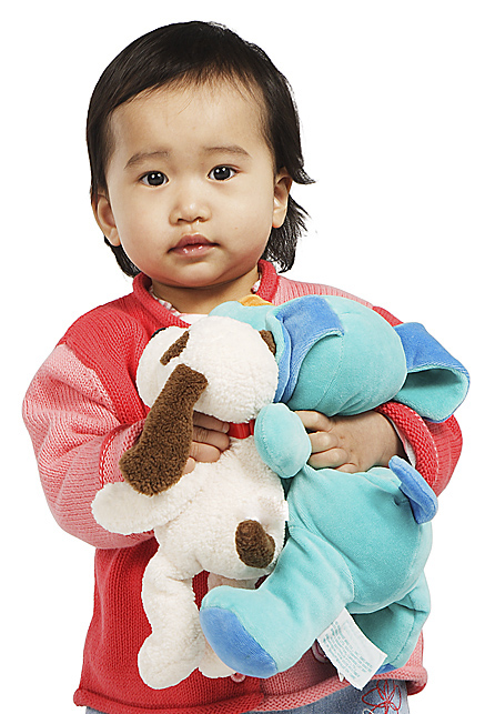 Niña pequeña carga tres muñecos de peluche