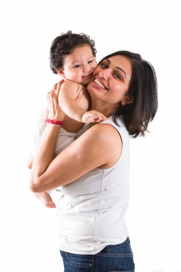 Mamá erguida cargando a su bebé sonriente
