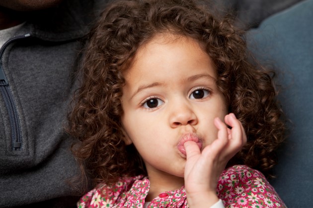 Niña pequeña chupando su dedo