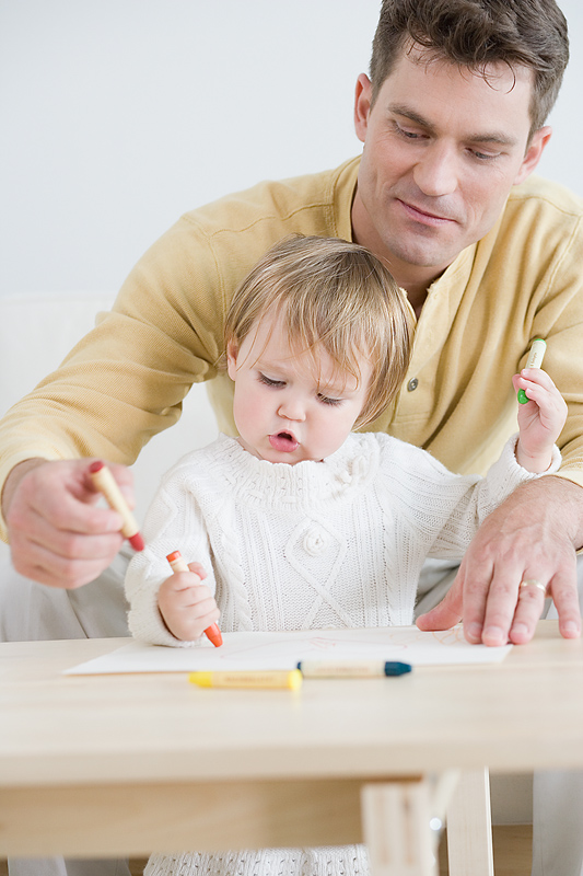 Dad and child coloring together at the table